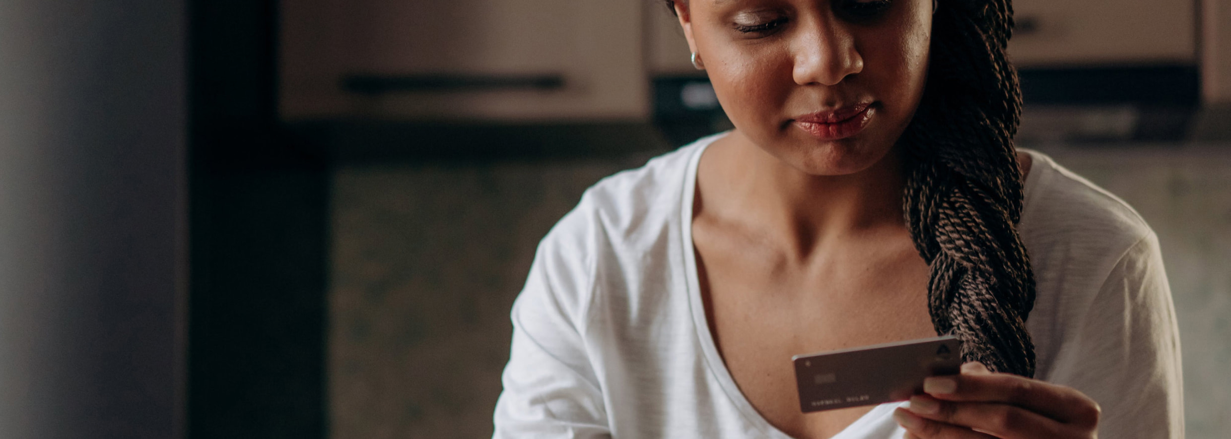 Woman holding a Netspend card in front of a computer