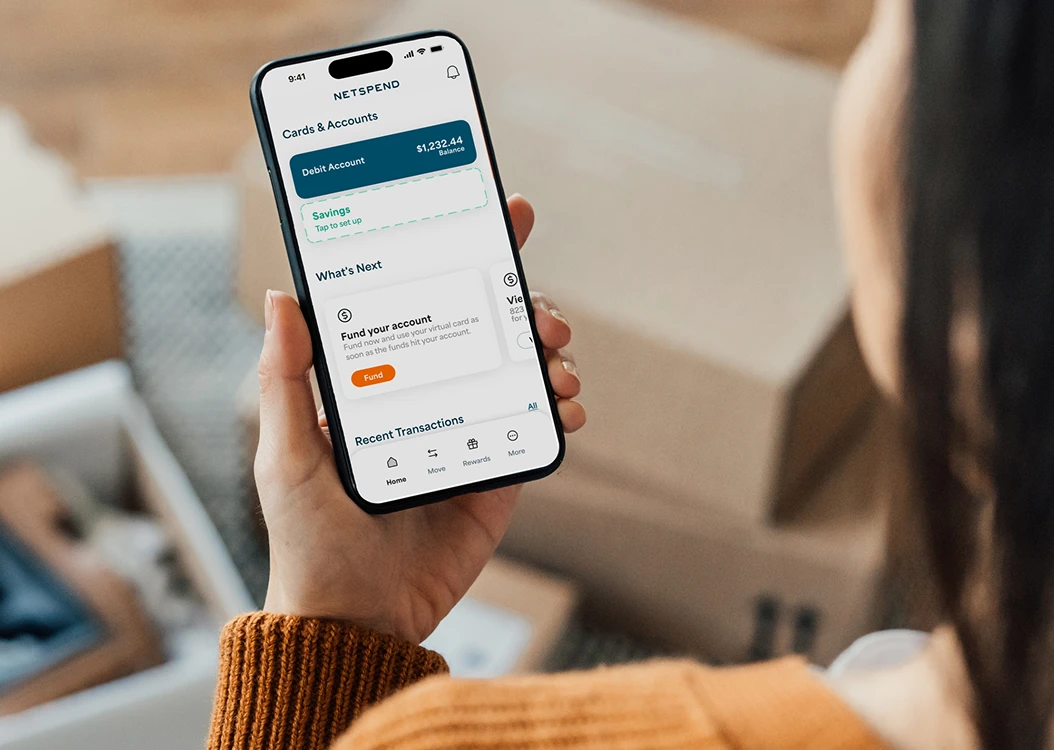 Woman holding an iPhone showing her account balance in the Netspend appt