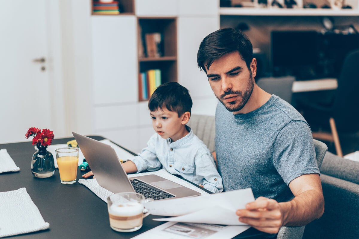 Man Working from Home with Son in his Lap